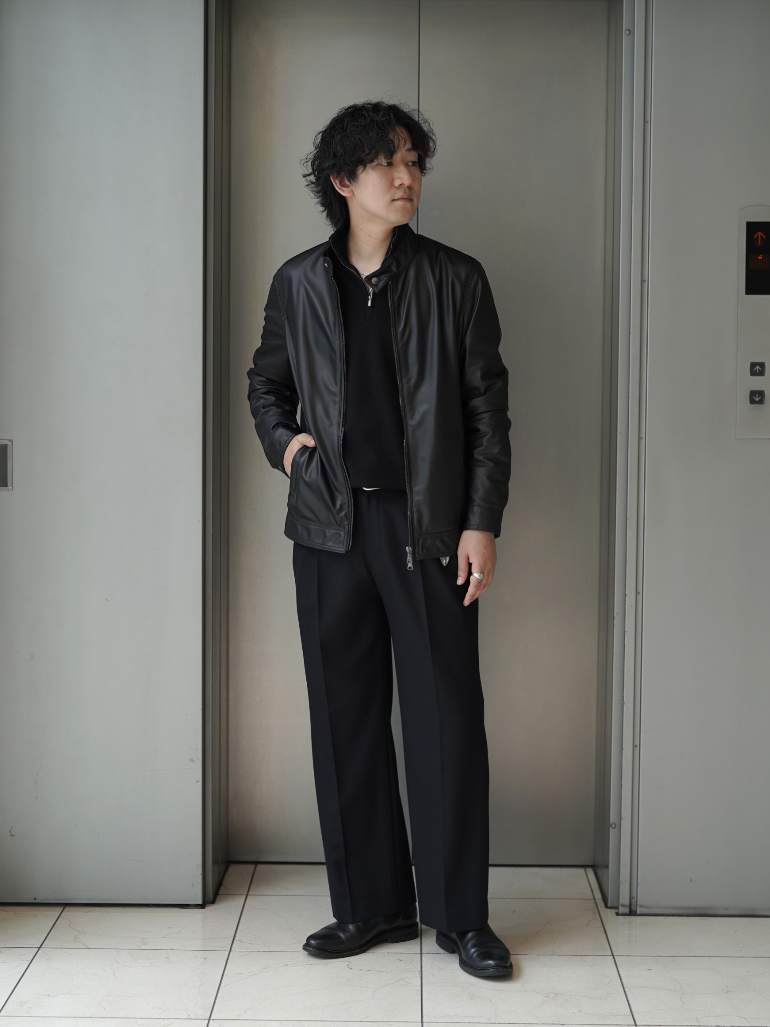 黒のレザージャケットとハーフジップニット、スラックスの全身スタイリング